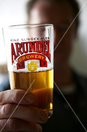 Man holding up a glass of beer