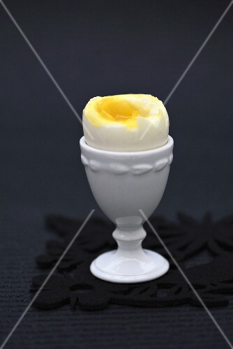 Soft-boiled egg with top removed in egg cup