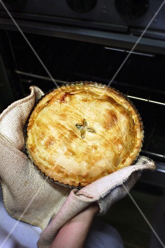 Frisch gebackene Pie aus dem Ofen nehmen