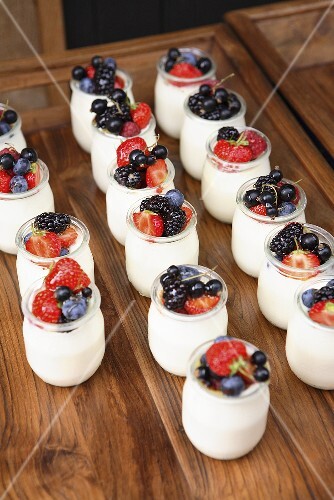 Viele Gläser Joghurt mit frischen Beeren