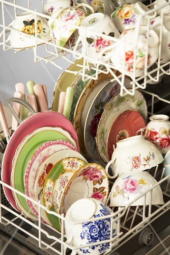 Opened dishwasher with crockery