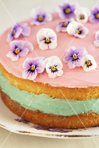 Sponge cake with pink icing and pansies