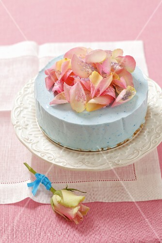 A blue cheesecake with rose petals