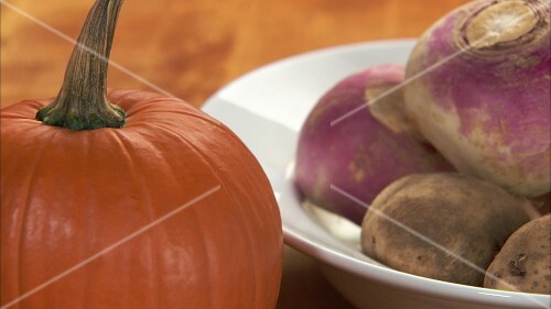 Pumpkin, turnips and potatoes, hand taking a turnip