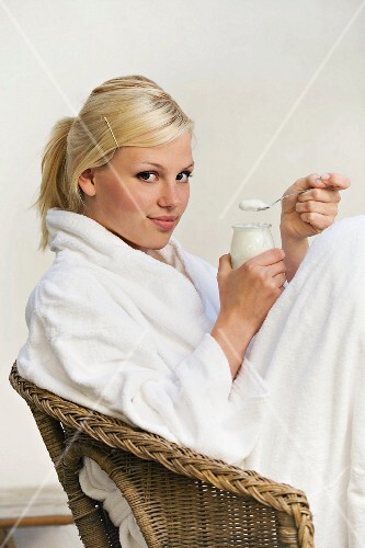 Junge, blonde Frau mit Joghurt