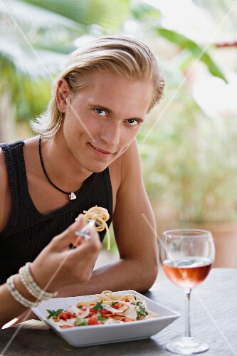 Junger Mann isst Spaghetti