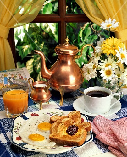 Frühstücksszene mit Toast, Spiegelei, Kaffee und Orangensaft