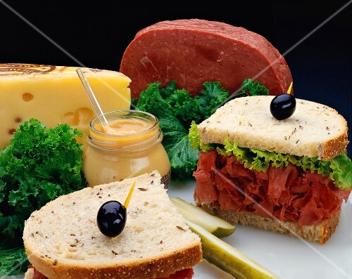 Roggenbrotsandwich mit Corned Beef, sowie Zutaten dahinter