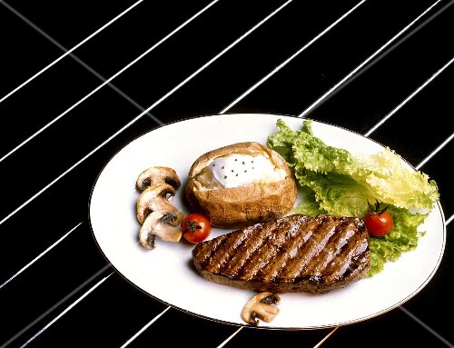 Gegrilltes Rindersteak mit Baked Potato auf weissem Teller
