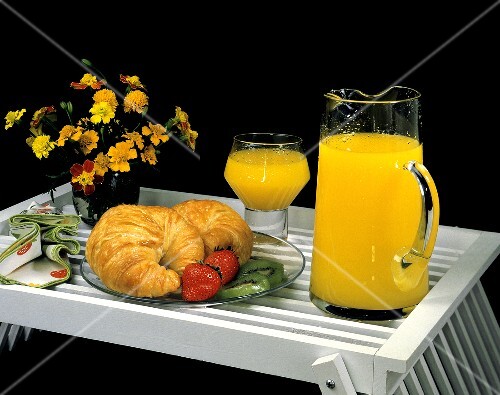 Croissants mit Erdbeeren & Kiwis & Orangensaft auf Tablett