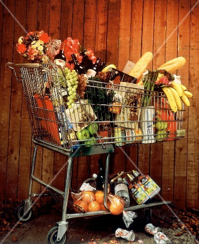 A Full Shopping Cart and a Wooden Fence  See Image #612563