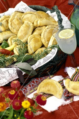 Empanadas in a Basket; Fresh Herbs and Beverage