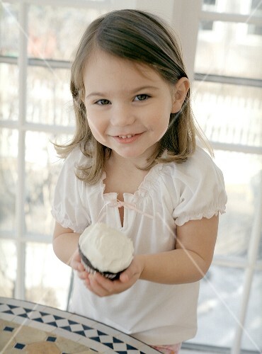 Small girl with a chocolate cup-cake
