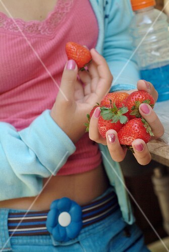 Junges Mädchen hält frische Erdbeeren