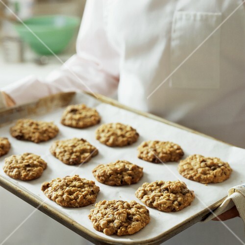 Chef serving oat biscuits on baking tray