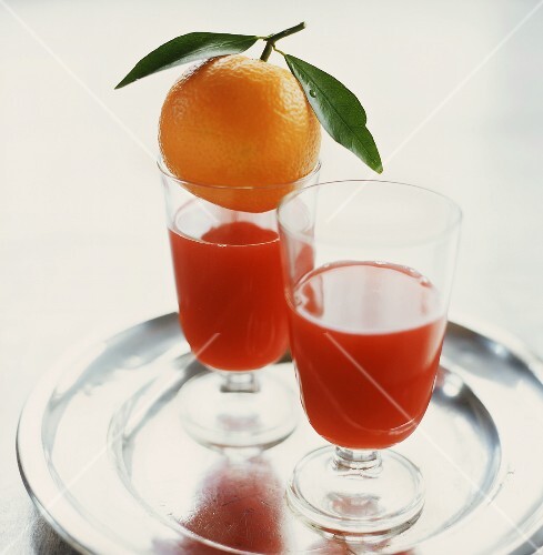 Two glasses of blood orange juice on tray
