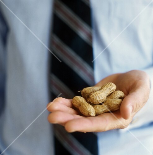 Man in tie holding peanuts in his hand