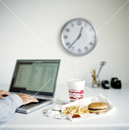 Fast food in the office: hamburger with chips and Cola
