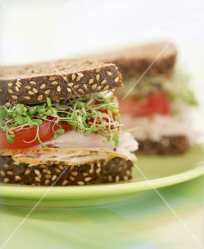 Sandwich, halbiert, mit Pute, Tomate und Sprossen