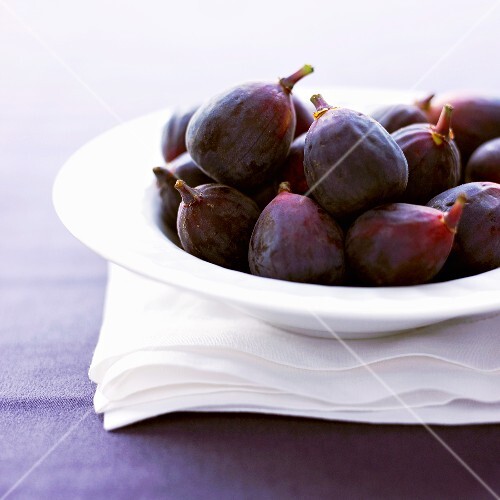 Fresh Figs in a White Bowl on White Linen