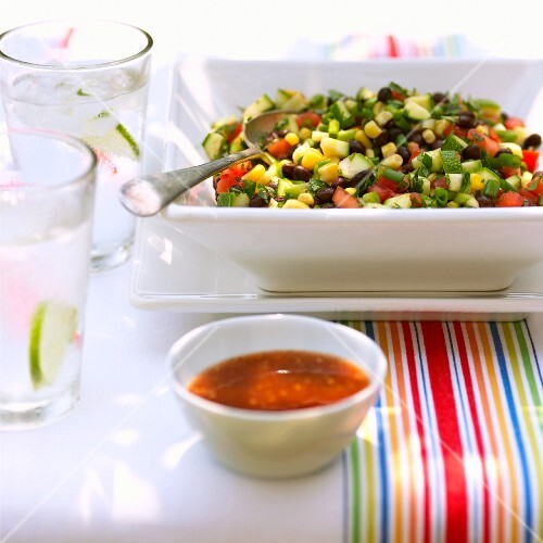 Bunter Bohnensalat, Dressing und zwei Gläser Eiswasser