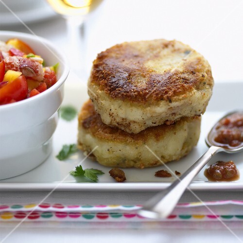 Zwei Fischpuffer und ein Löffel Sauce