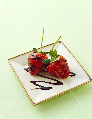 Zwei frische Erdbeeren mit Schokoladensauce
