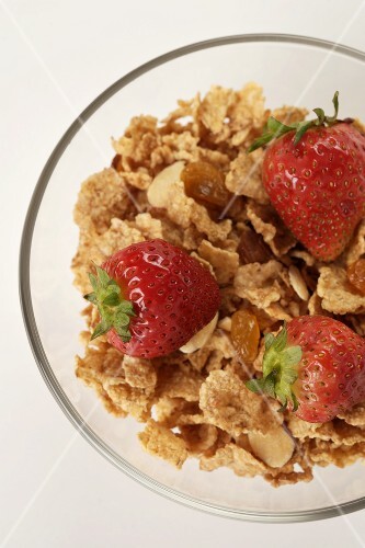 Bowl of Flake Cereal with Almonds and Dried Fruit Topped with Strawberries