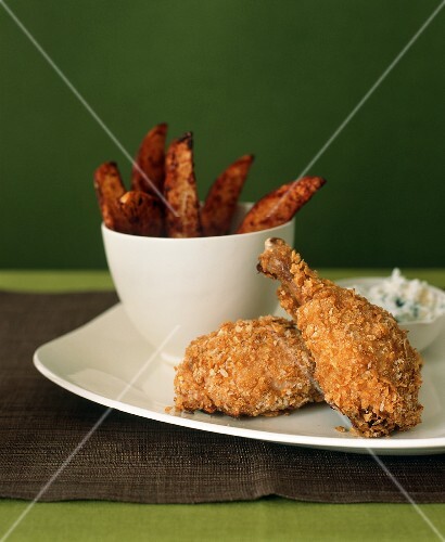 Crispy Chicken Drumsticks on a Plate with a Bowl of Oven Fries