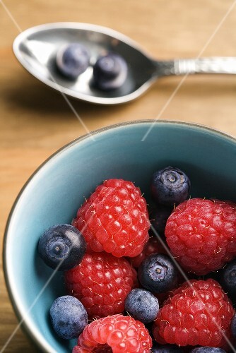 Organic Raspberries and Blueberries in a Blue Bowl