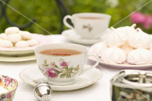 Tea Time; Cups of Tea with Meringue Cookies on an Outdoor Table