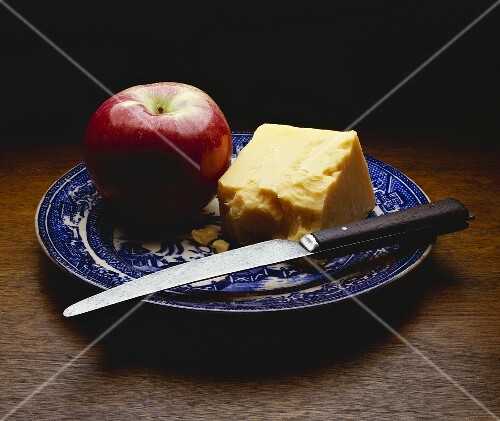 Ein Apfel und ein Stück Cheddar mit Messer