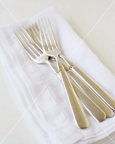 Silver forks on fabric napkin