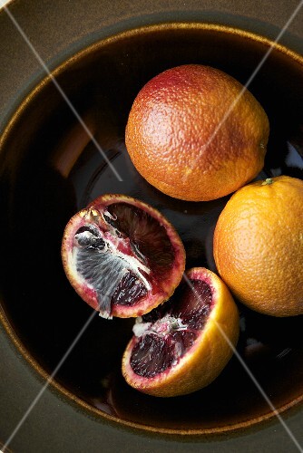 Blood Oranges in a Bowl; Two Whole and One Halved
