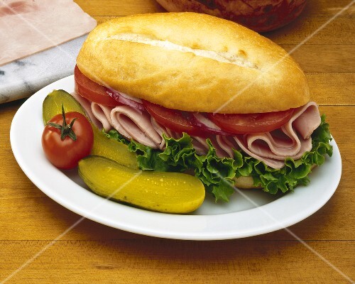 Ham and Tomato Sandwich with Pickle on White Plate