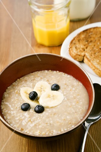 Bowl of Irish Oatmeal with Bananas and Blueberries; Toast and Juice